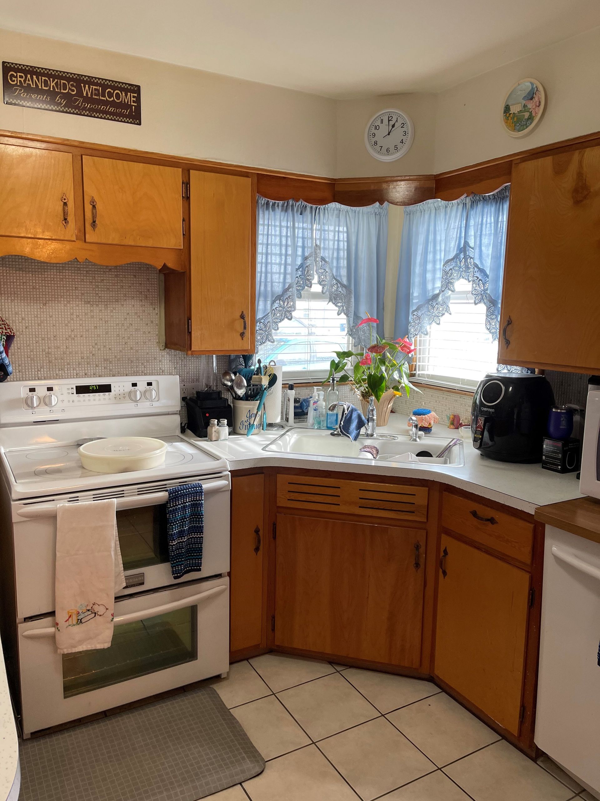 A kitchen with wooden cabinets and a white stove