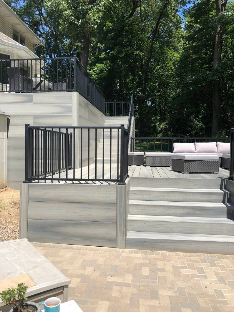 A large deck with stairs leading up to it and a couch on it.
