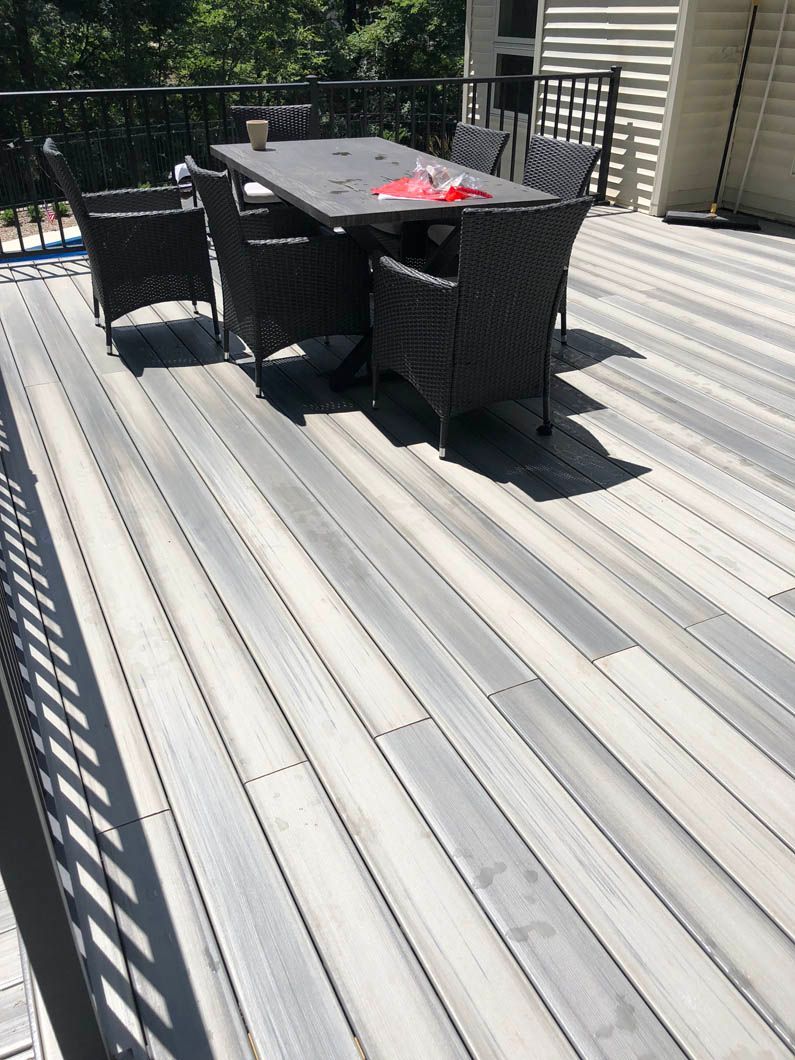 A wooden deck with a table and chairs on it.