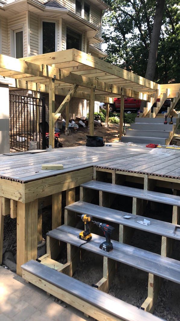 A wooden deck is being built in front of a house.