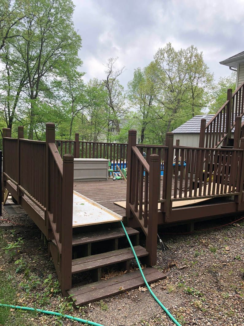 A wooden deck with stairs and a hose attached to it.