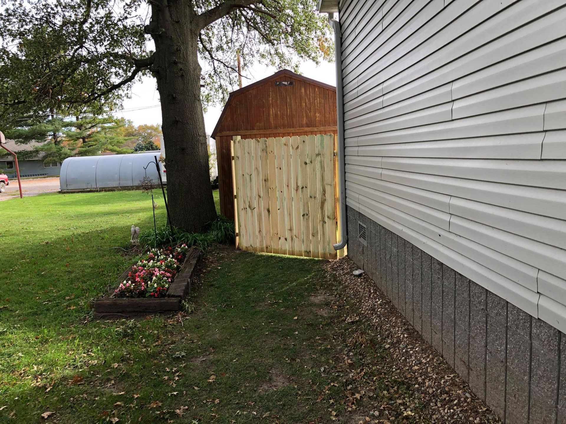 A wooden fence is sitting next to a white house.