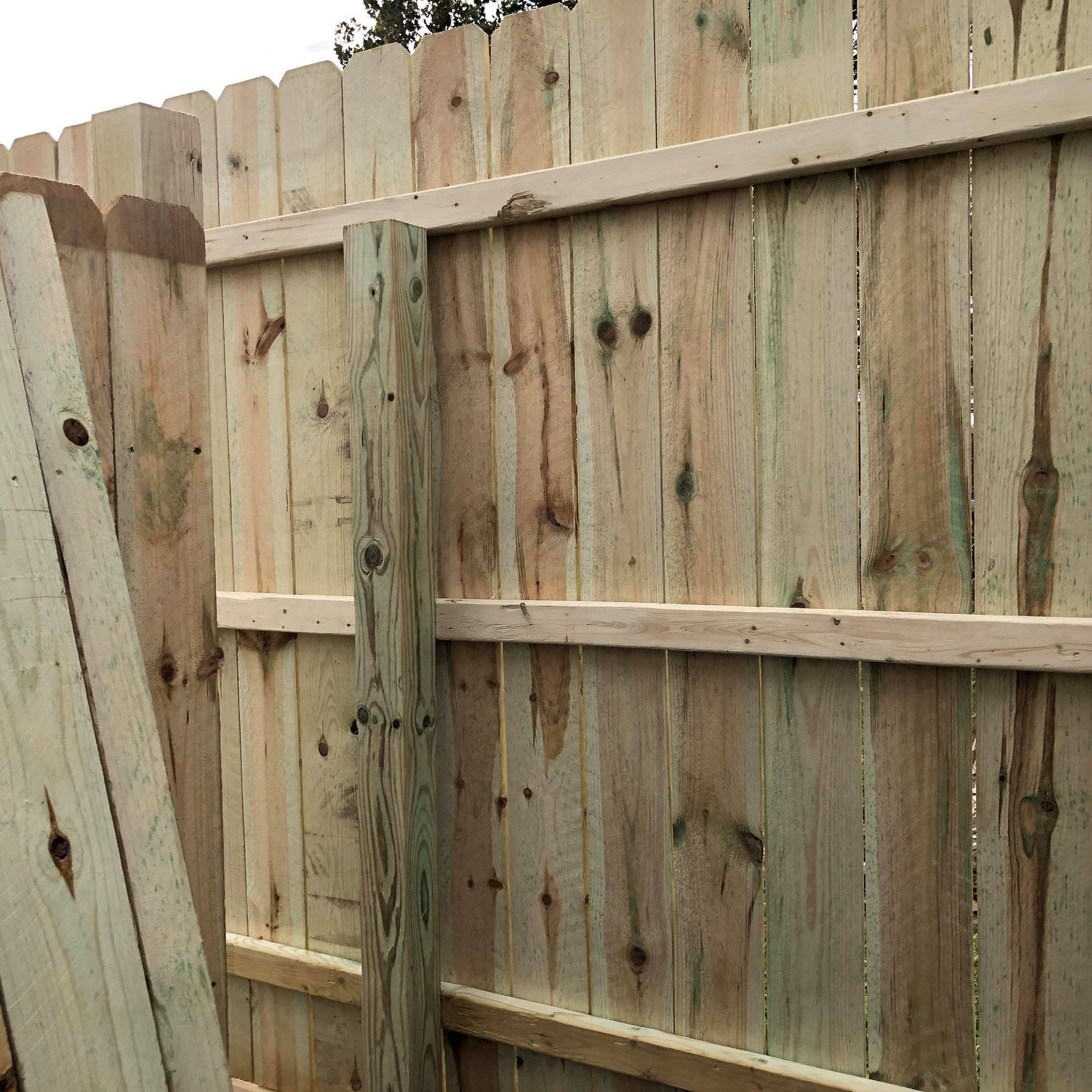A wooden fence is being built in a yard