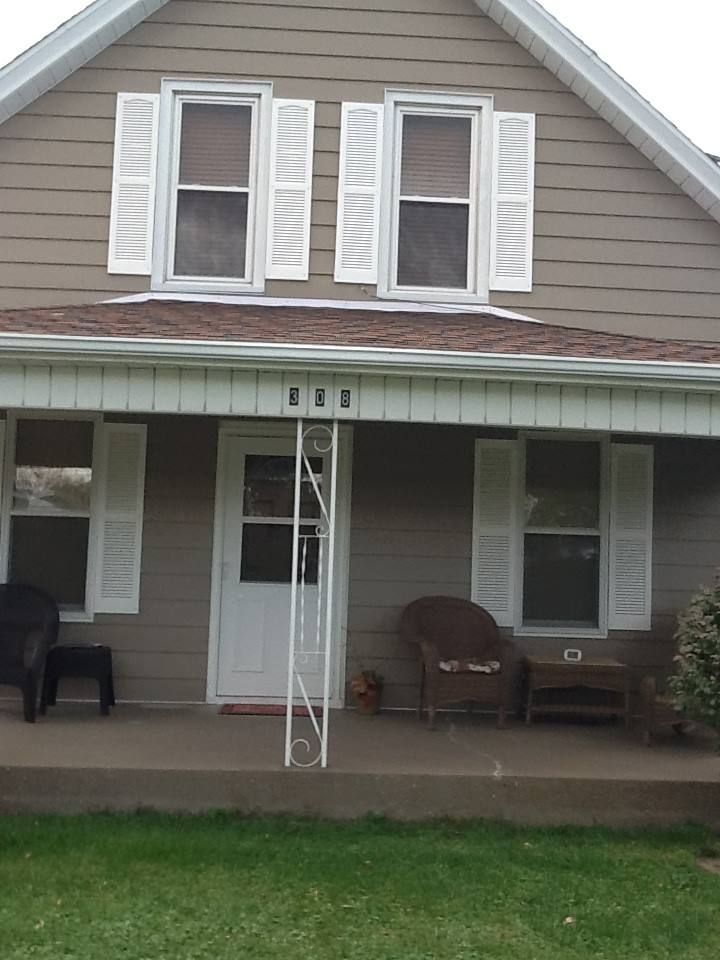 A house with a porch and shutters on the windows