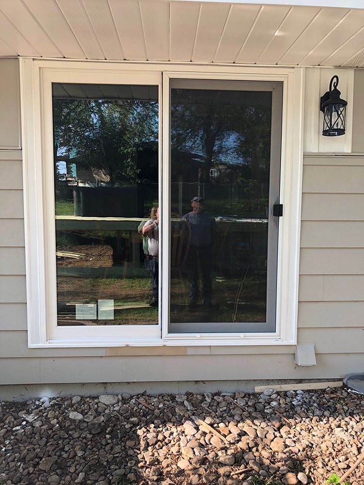 A sliding glass door is on the side of a house.
