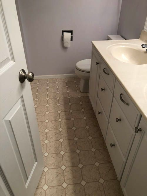 A bathroom with a toilet , sink , and drawers.