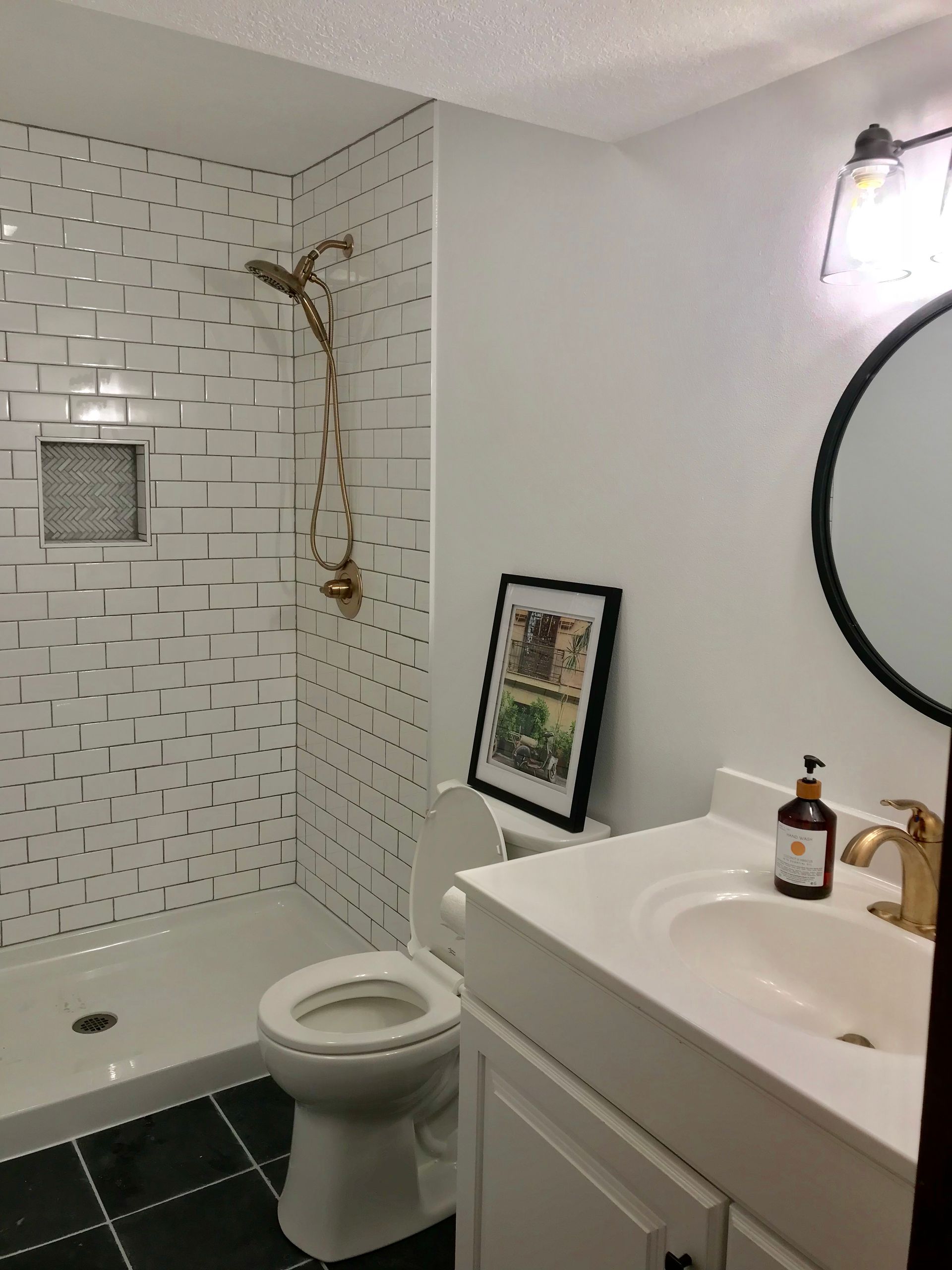 A bathroom with a toilet a sink and a shower