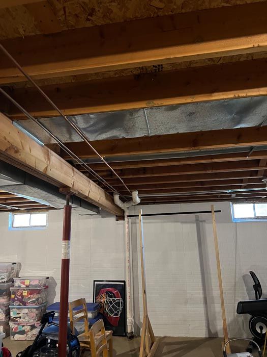 A basement with wooden beams and a metal ceiling.