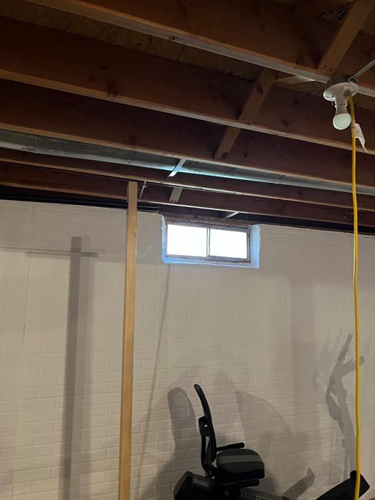 A ceiling fan is hanging from the ceiling in a basement