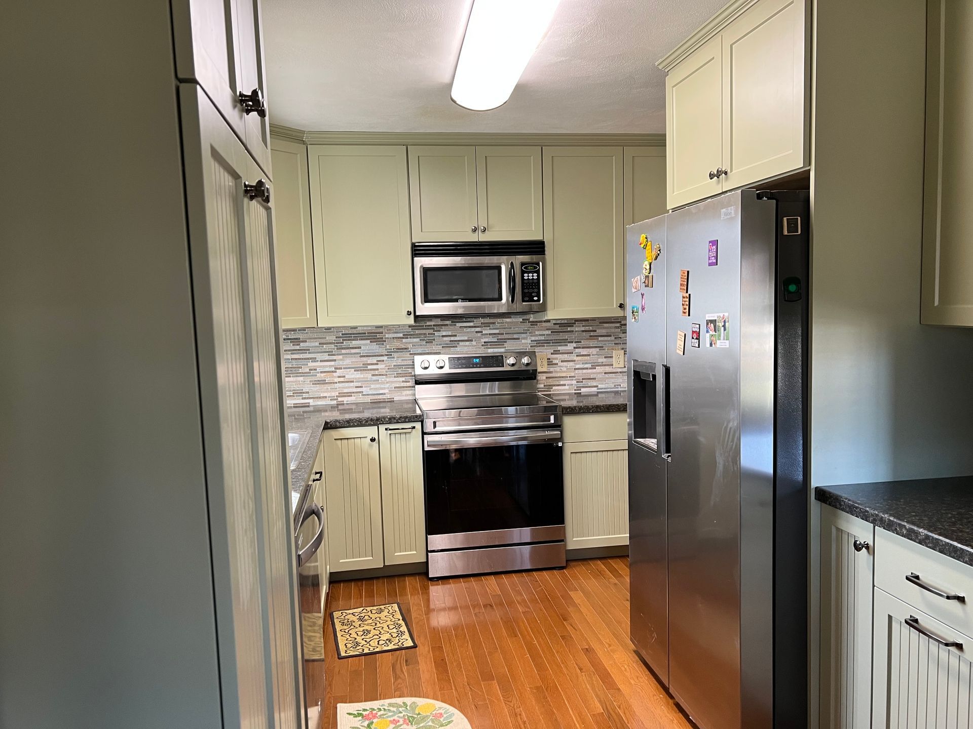 A kitchen with stainless steel appliances and white cabinets