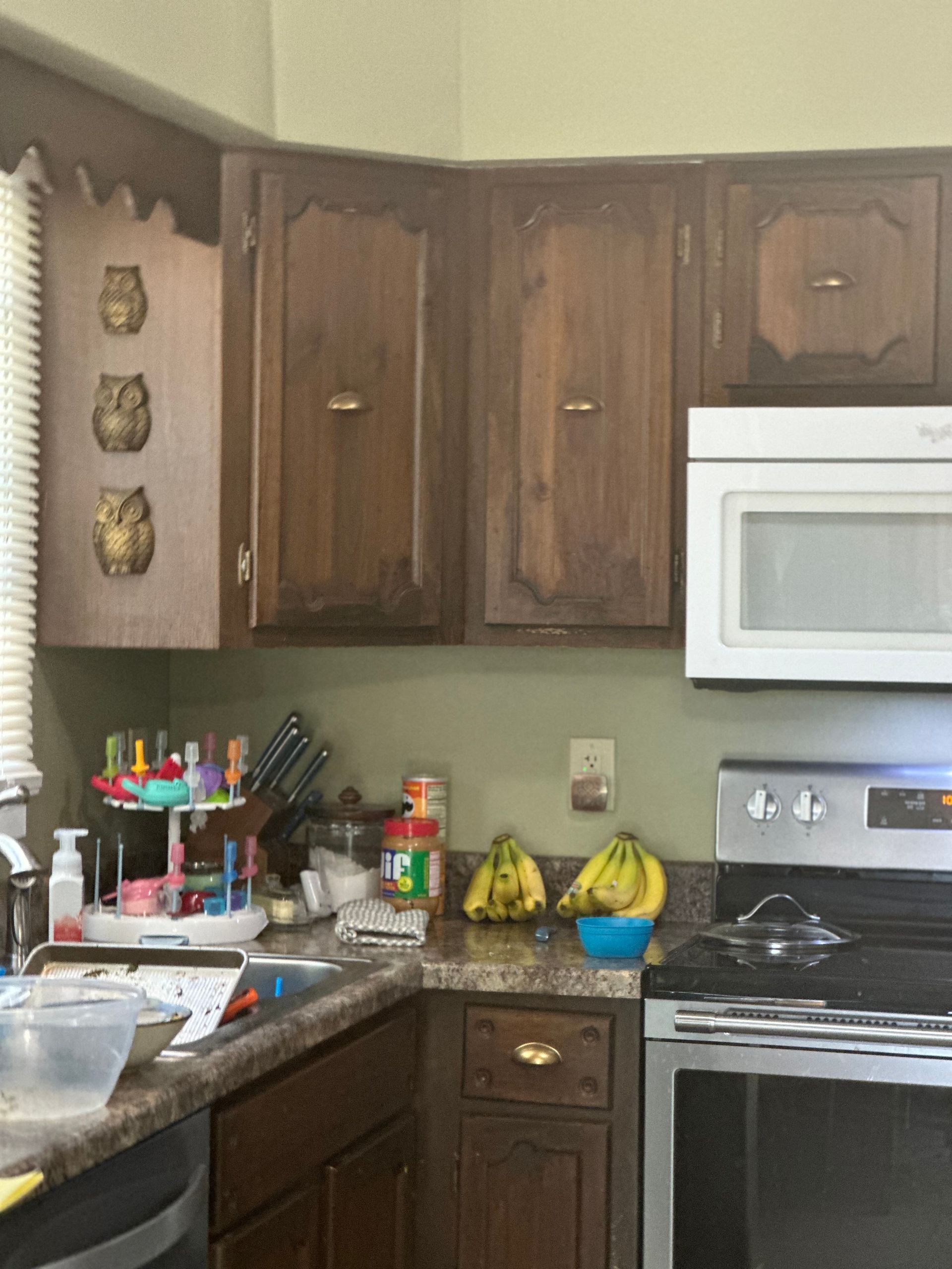 A kitchen with wooden cabinets and a white microwave