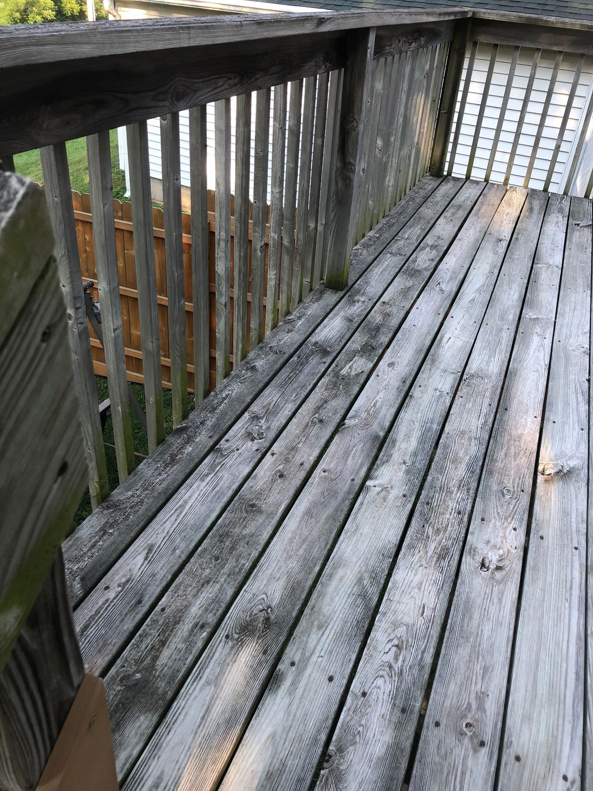 A wooden deck with a fence in the background.