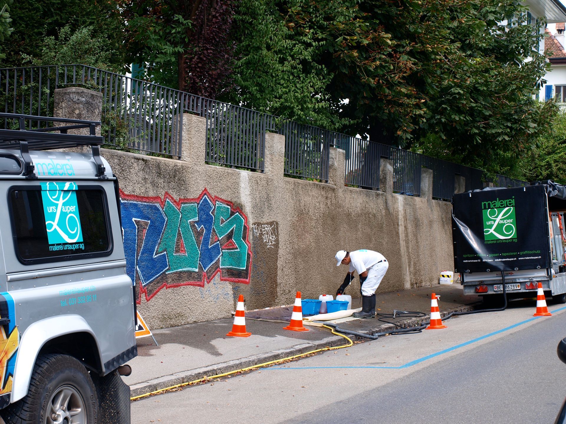Arbeit, bei der Graffiti von einer Wand entfernt wird