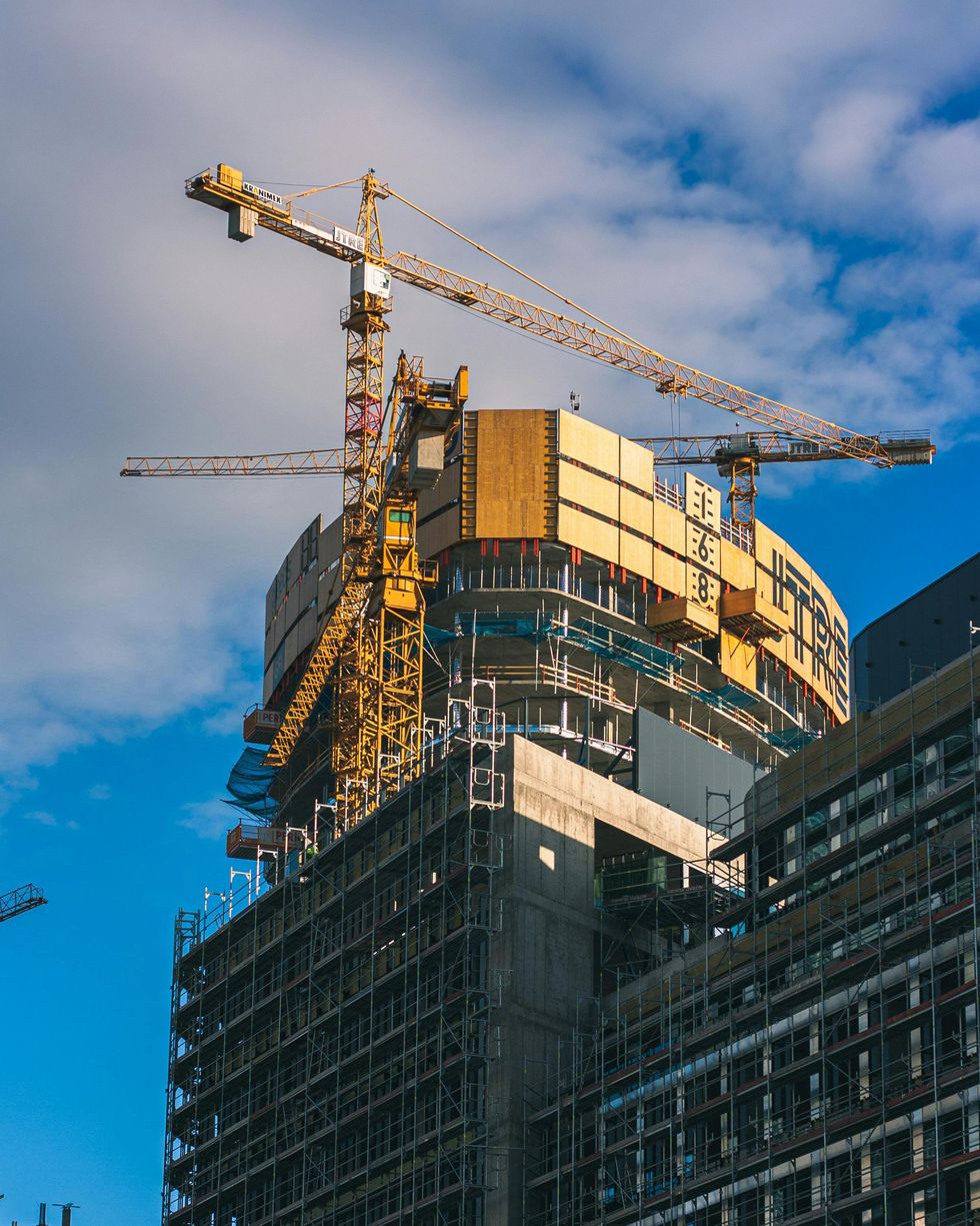 Obra en construcción con trabajadores con cascos y chalecos de seguridad 