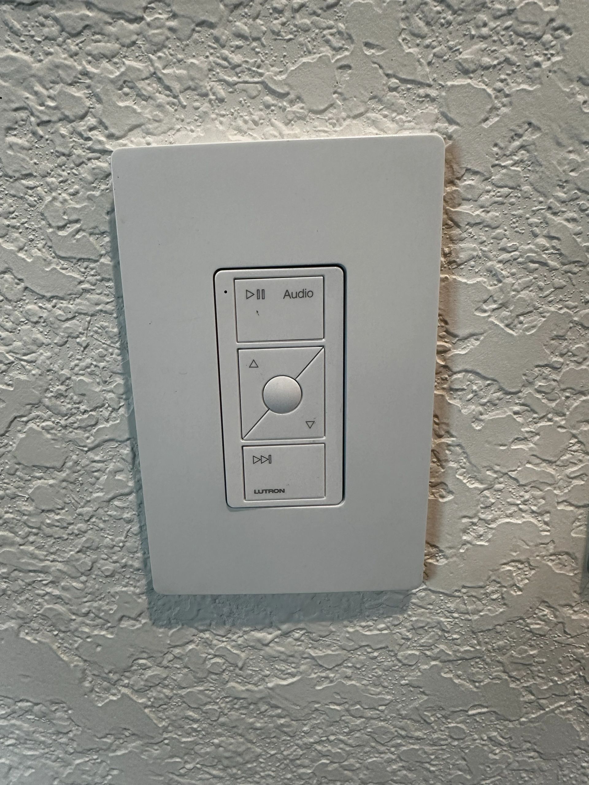 A white light switch is mounted on a white wall.