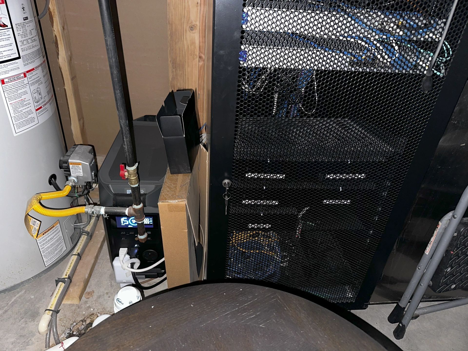 A water heater with a yellow hose attached to it