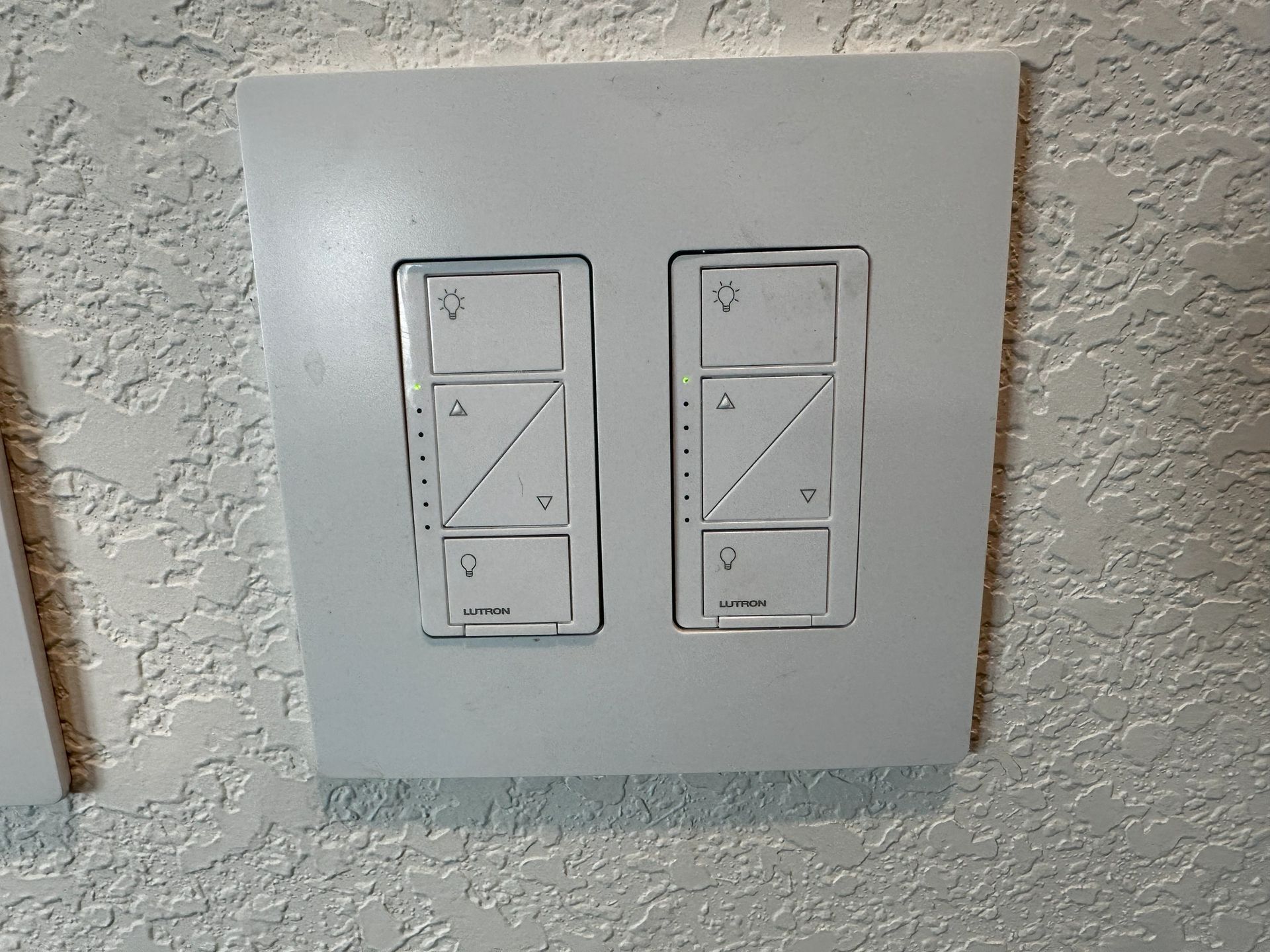 Two light switches are mounted on a white wall.