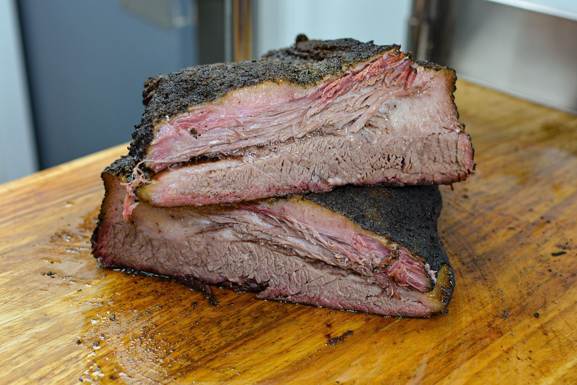 A sandwich with meat and onions on a bun on a wooden table.