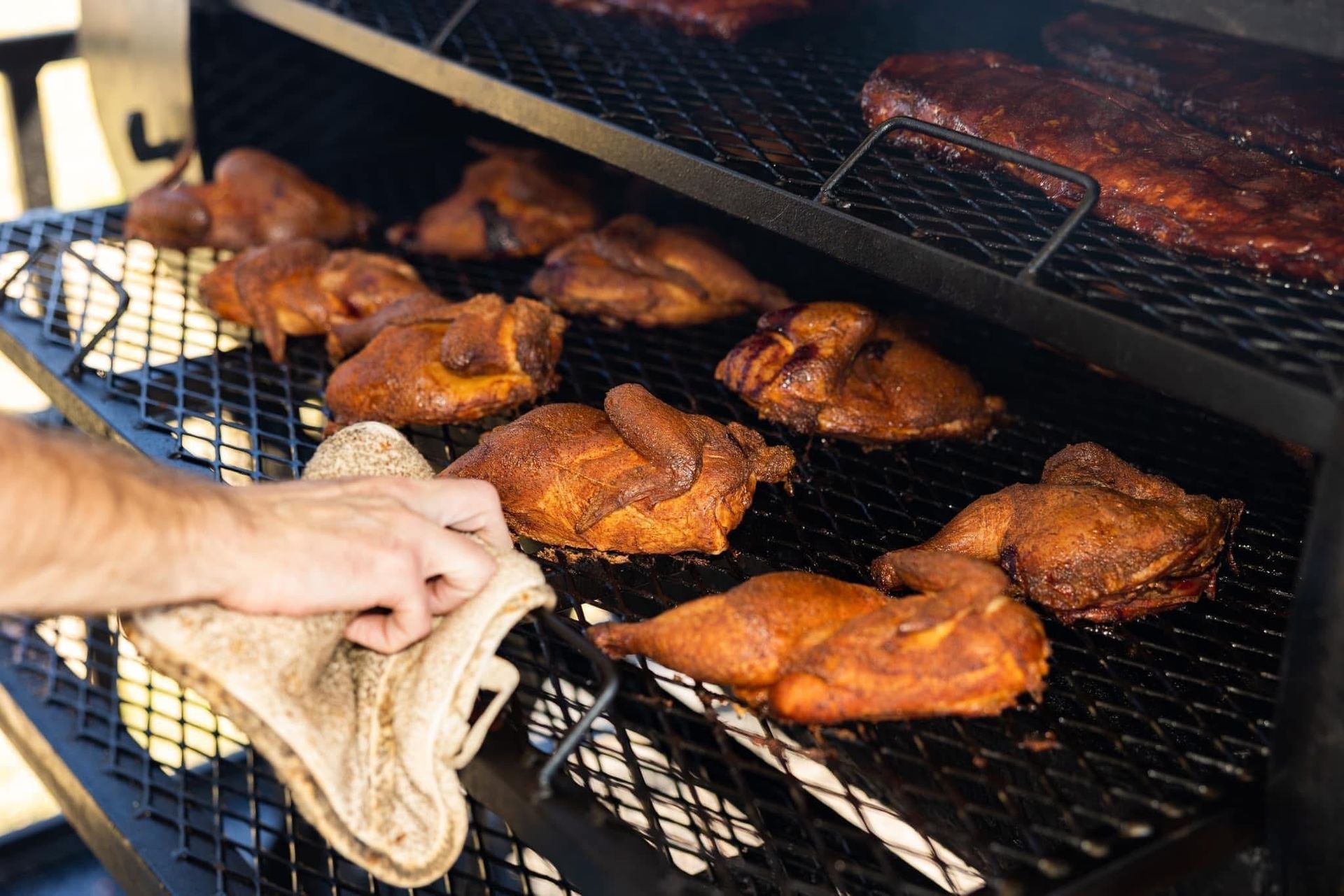 Chicken wings are being cooked in a smokehouse.