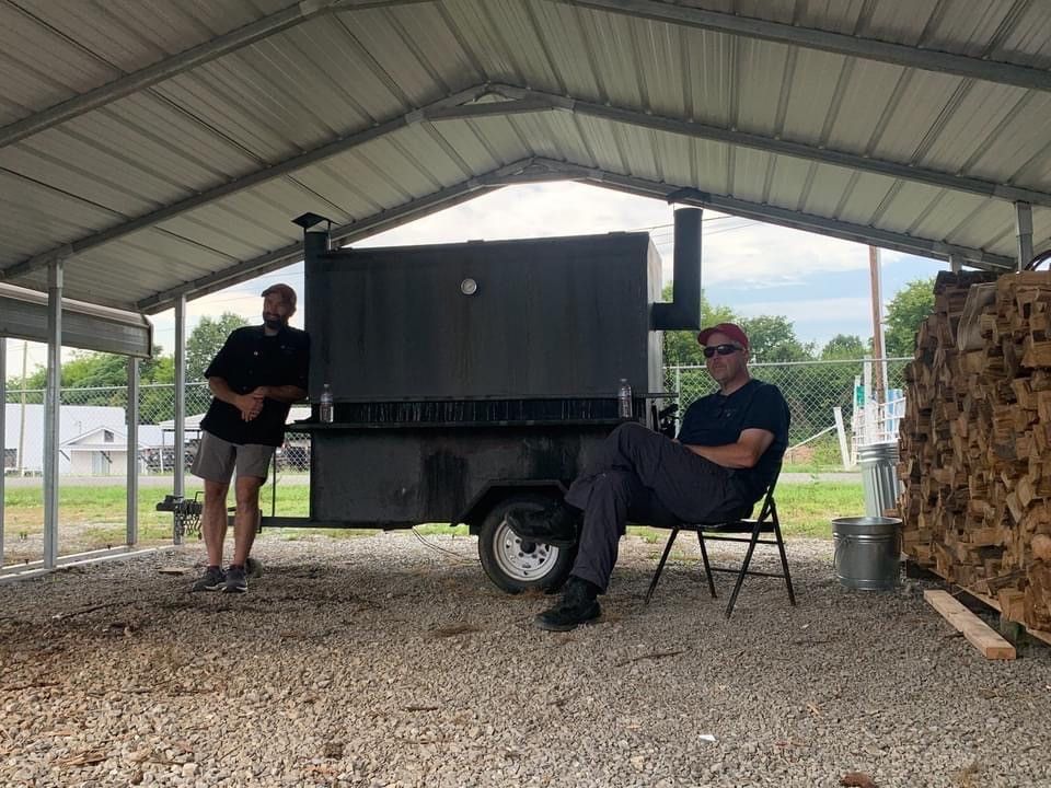 A sandwich with meat and onions on a bun on a wooden table.