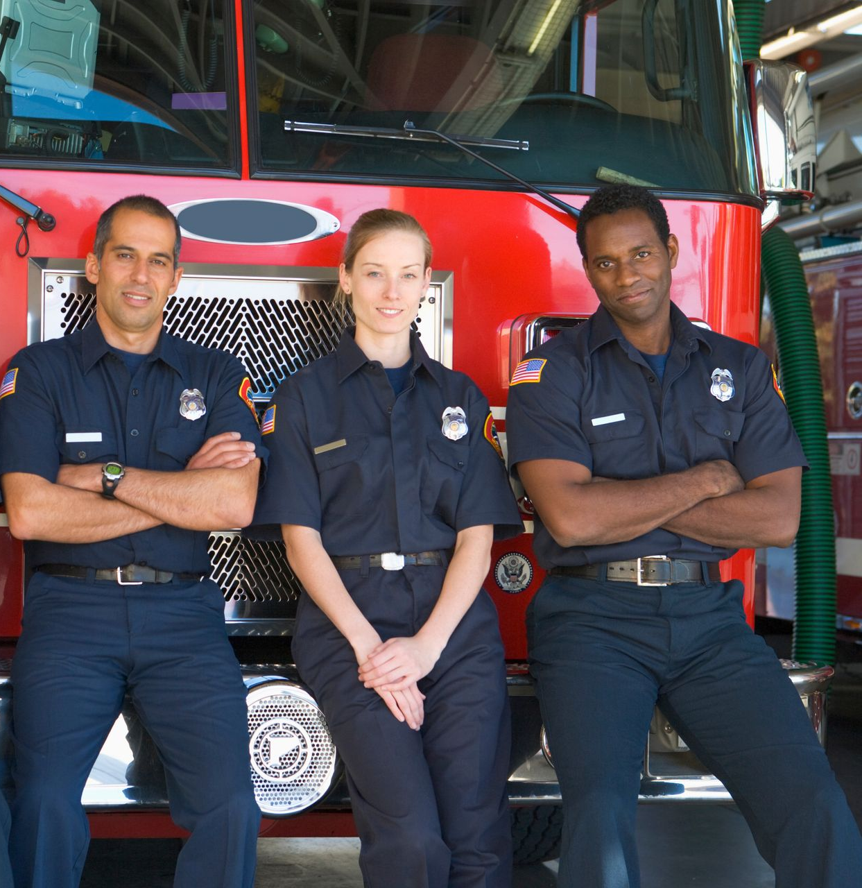 Woman in blue suit, hand on chin, looking at camera. Office shelves in background.