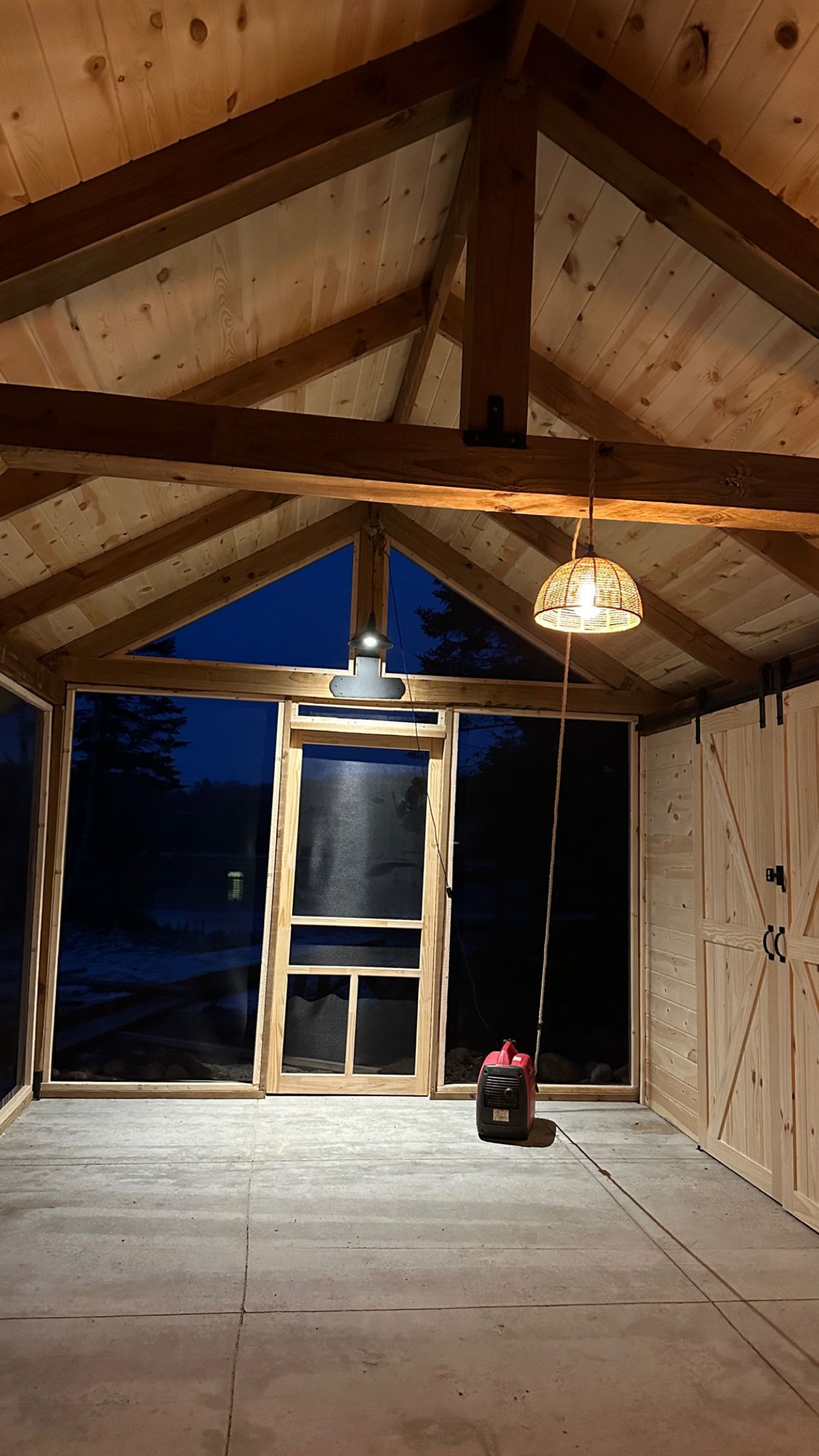 A room with a lot of windows and a light hanging from the ceiling.