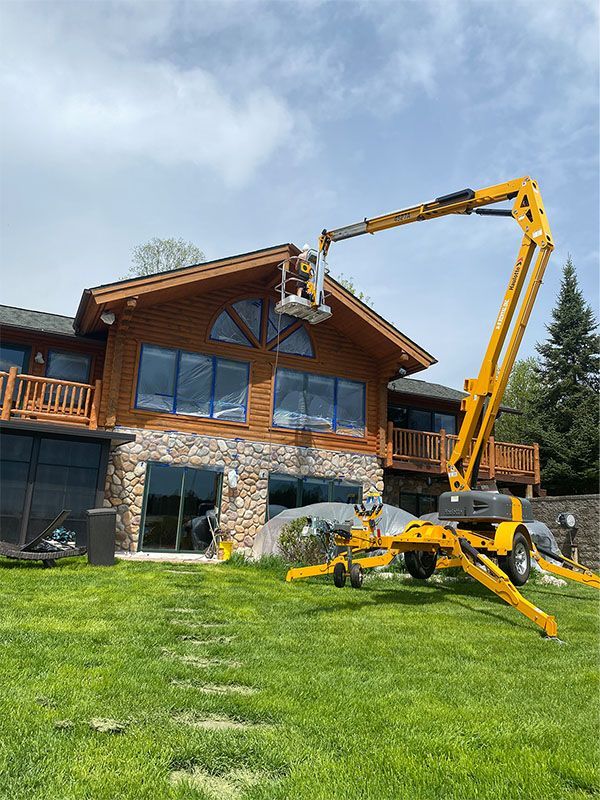A log cabin with a wooden deck and a toilet in front of it.