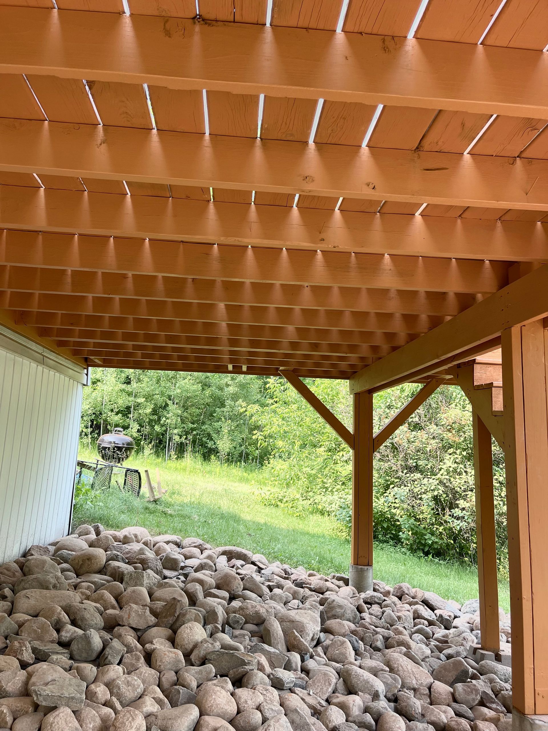 A wooden structure with a lot of rocks underneath it.