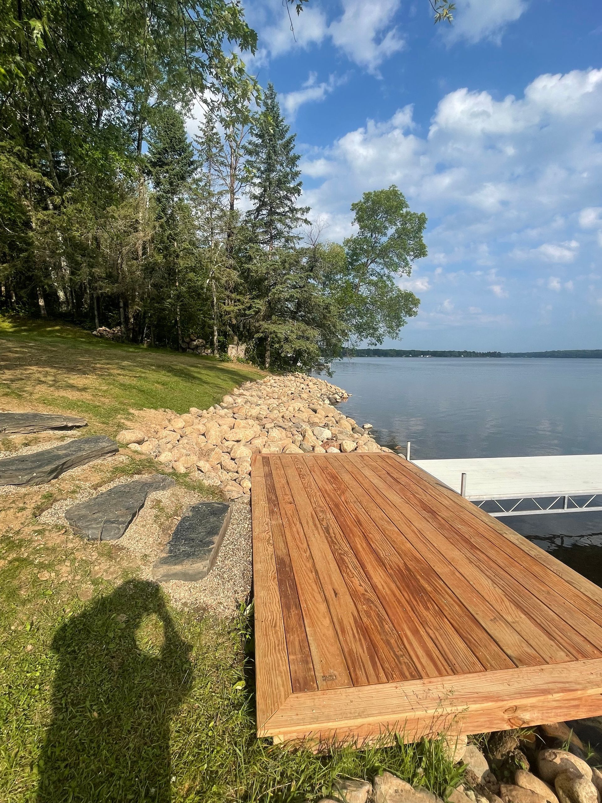 A wooden dock is sitting on the shore of a lake.