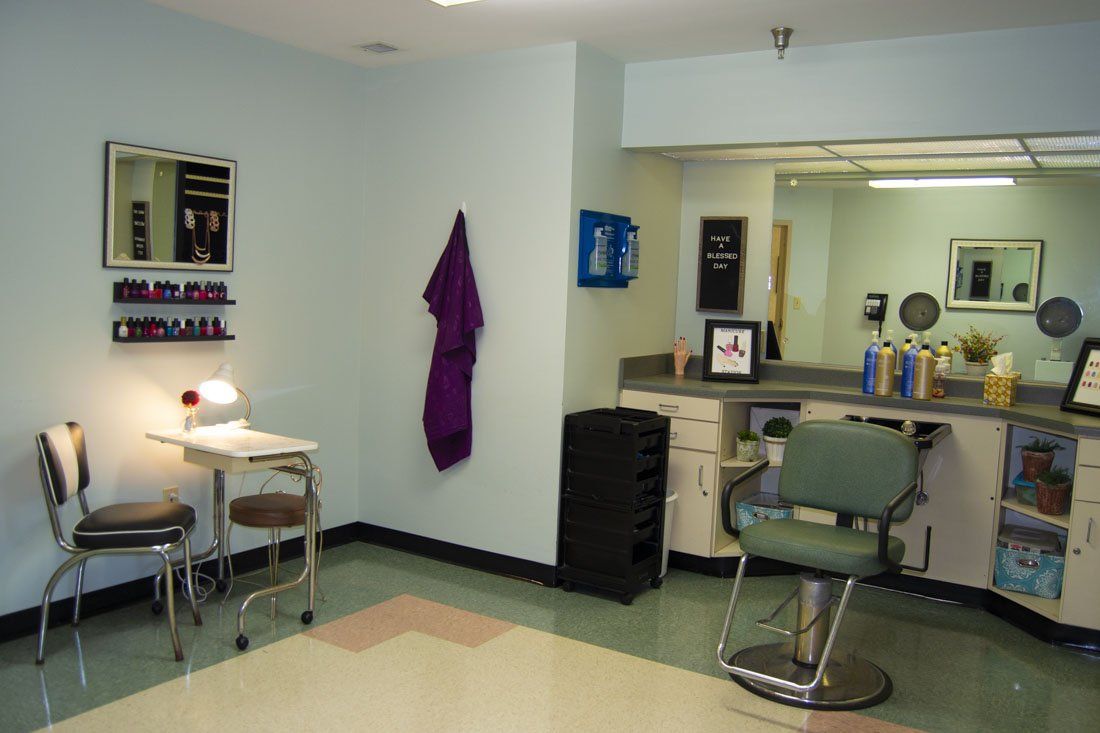 A hair salon with a green chair and a table