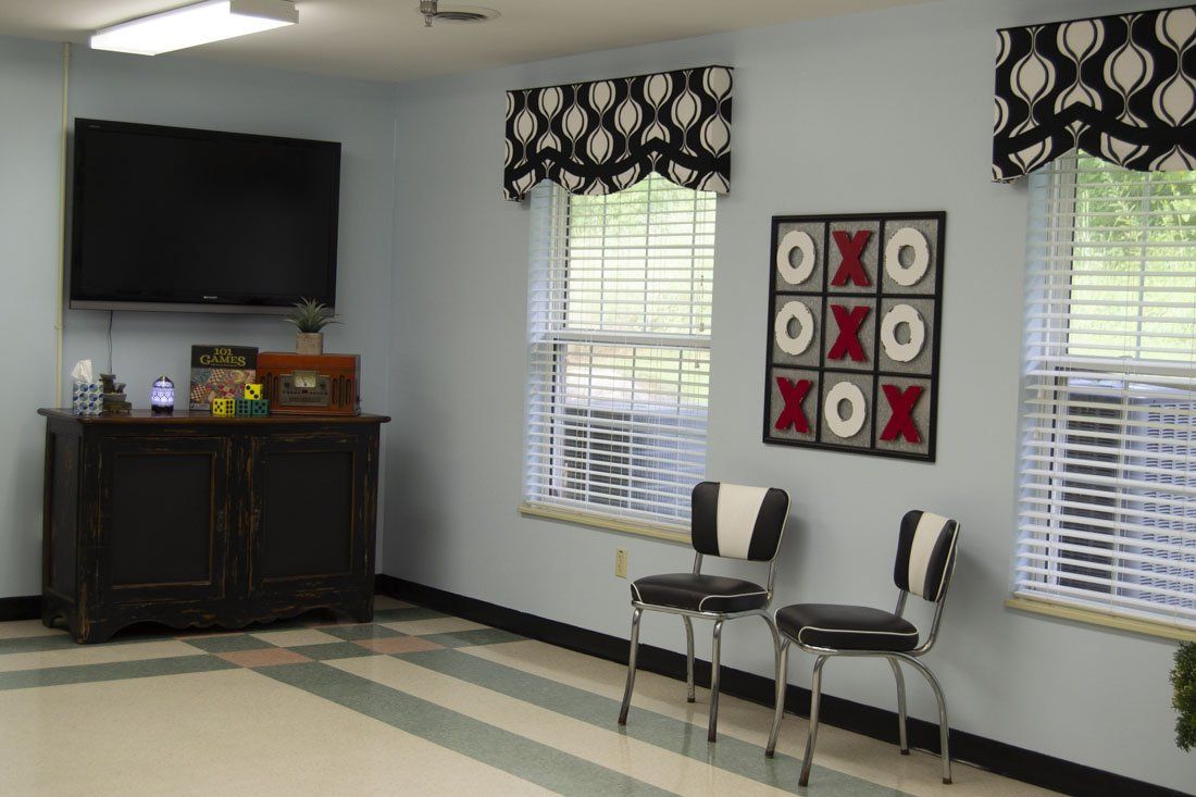 A room with two chairs and a tic tac toe board on the wall
