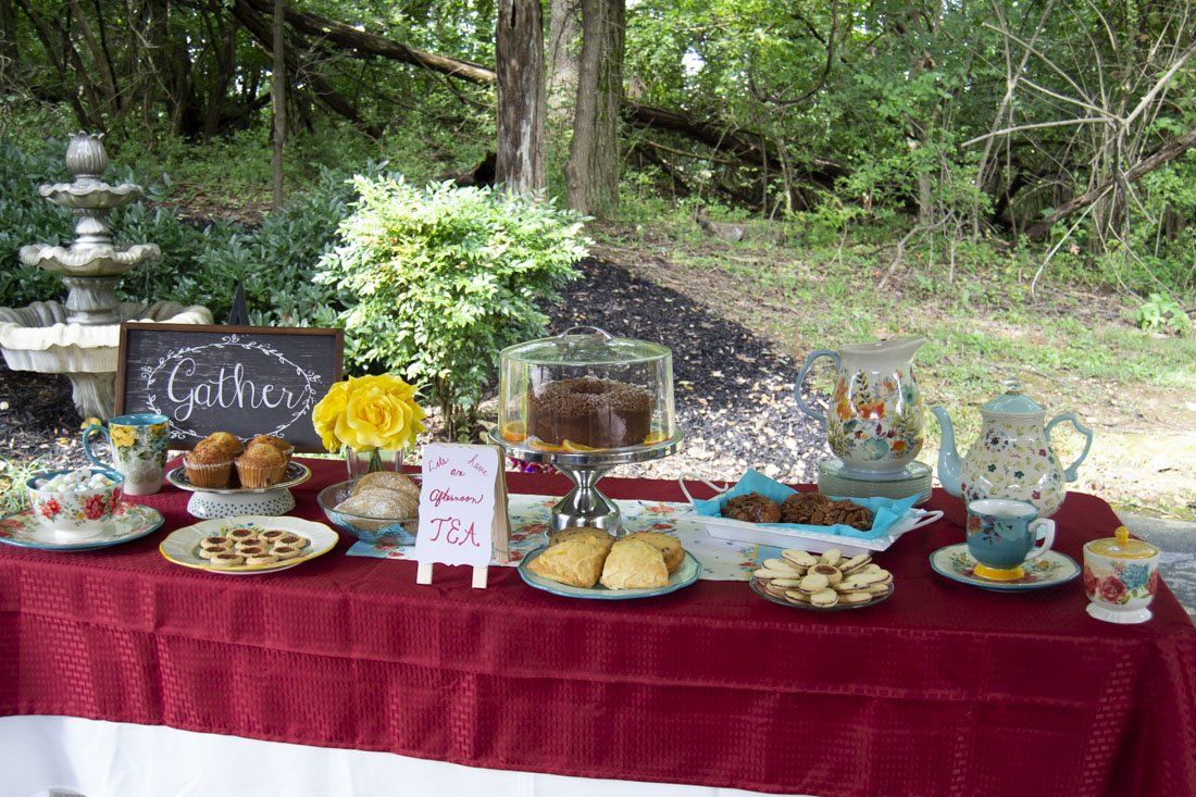 A table topped with plates of food and a sign that says `` gather ''.