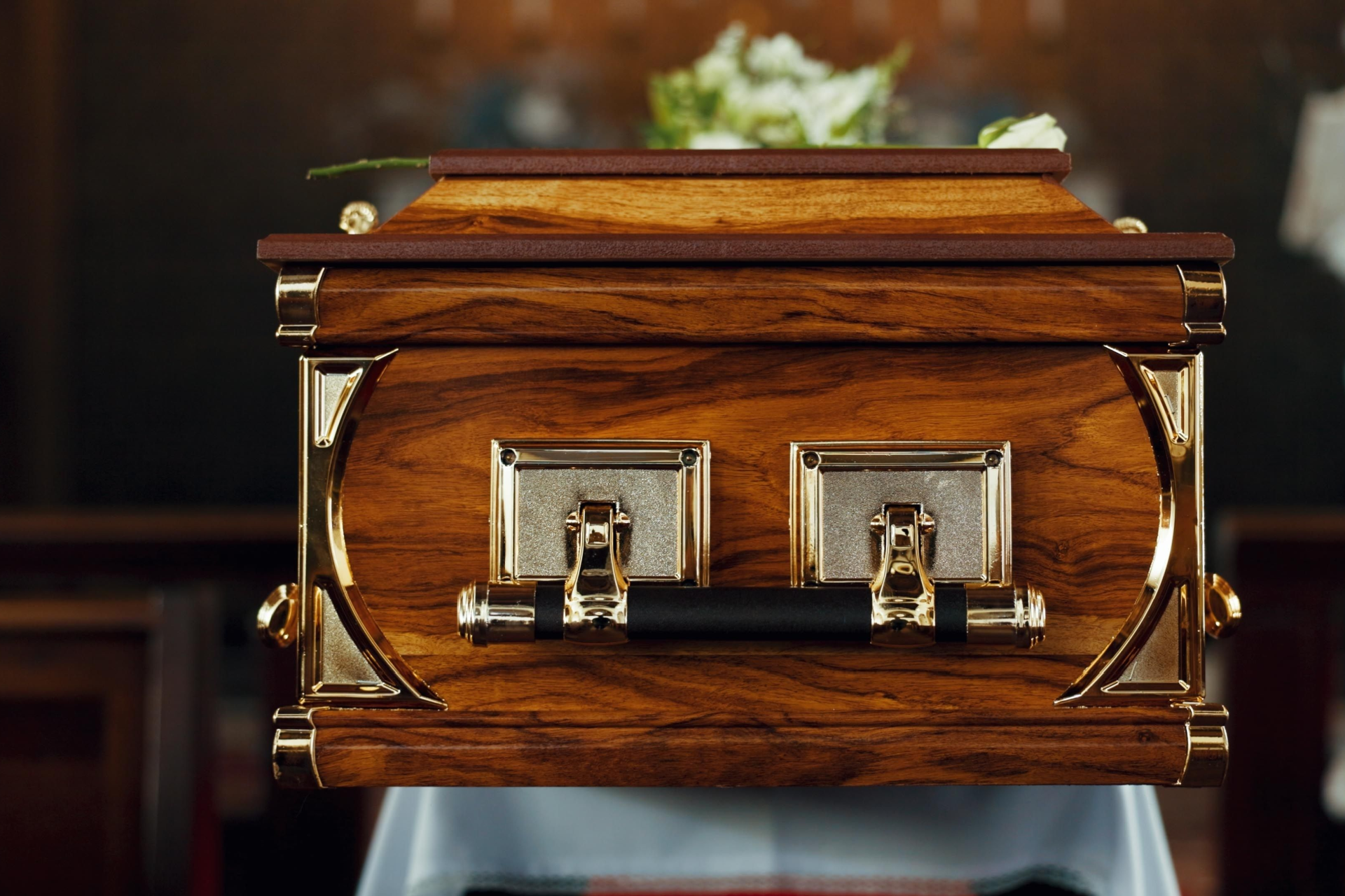 A wooden coffin with flowers on top of it in a church.
