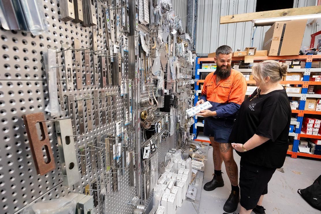 Man With Beard and Woman Looking at Hardware Display, Woman Appears Pregnant, Inside a Store — Active 24/7 Locksmith and Security Services in Seal Rocks, NSW