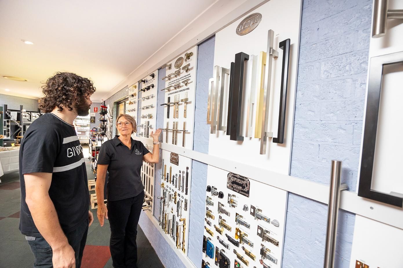 Customer and Shop Worker Looking at Door Handles in a Hardware Store — Active 24/7 Locksmith and Security Services in Wingham, NSW