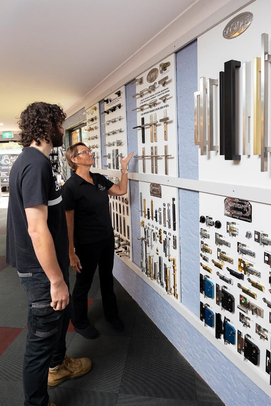 A Man and Woman Looking at Door Hardware Samples in a Store. The Woman Points to a Display — Active 24/7 Locksmith and Security Services in Old Bar, NSW