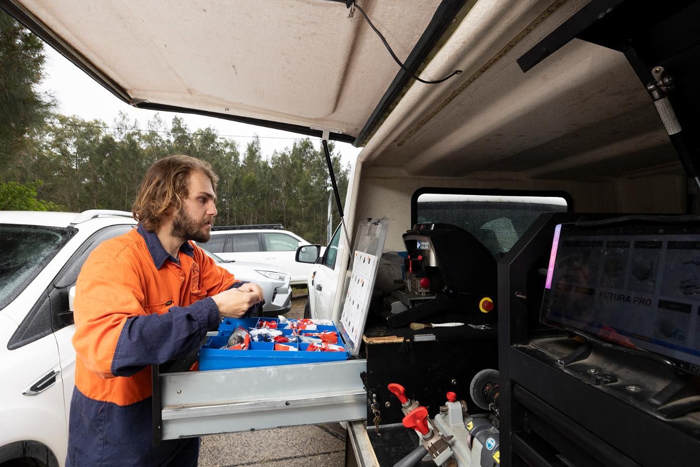 Man in Work Clothes Selecting Key Parts From a Van Toolbox — Active 24/7 Locksmith and Security Services in Forster, NSW