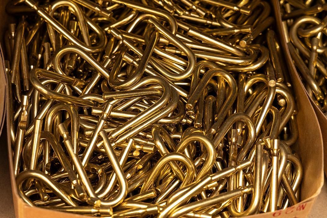 Close-up of a Pile of Golden-colored Metal Screw Hooks in a Cardboard Box — Active 24/7 Locksmith and Security Services in Bulahdelah, NSW