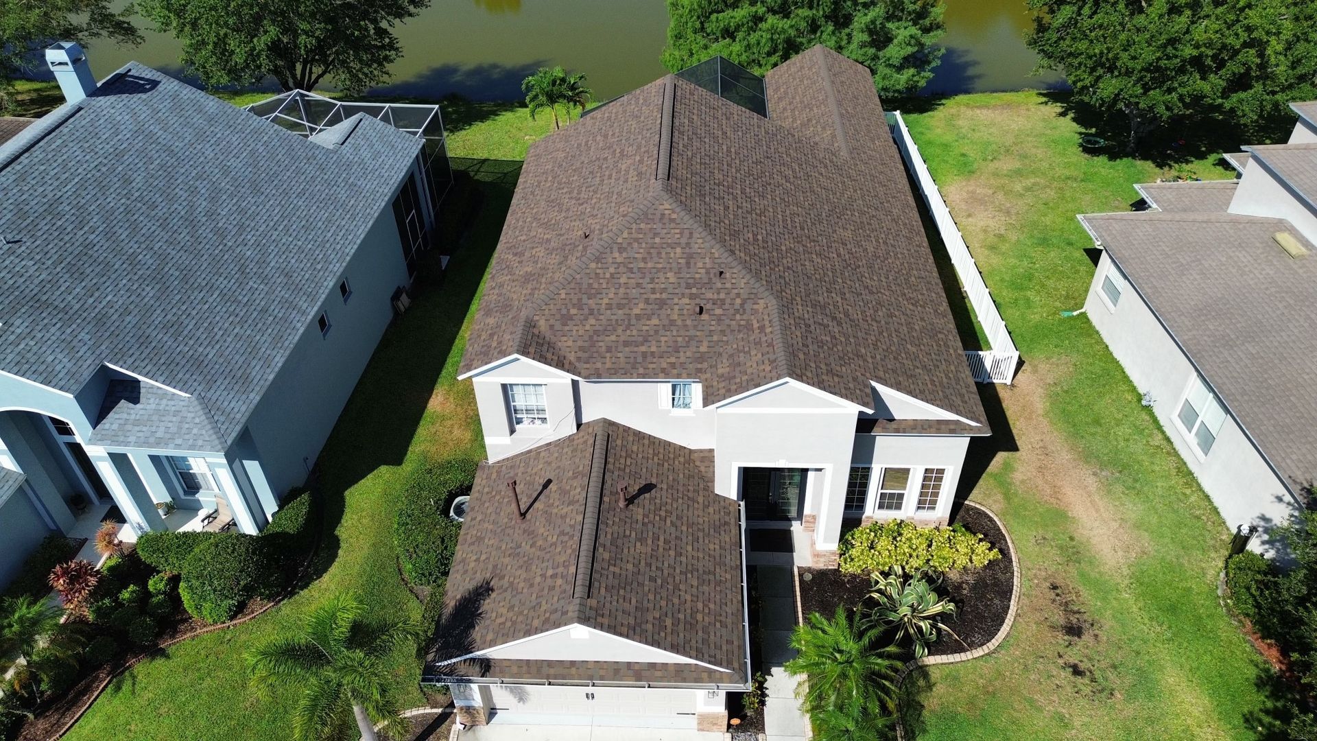 An aerial view of a house with a new roof in a residential area.