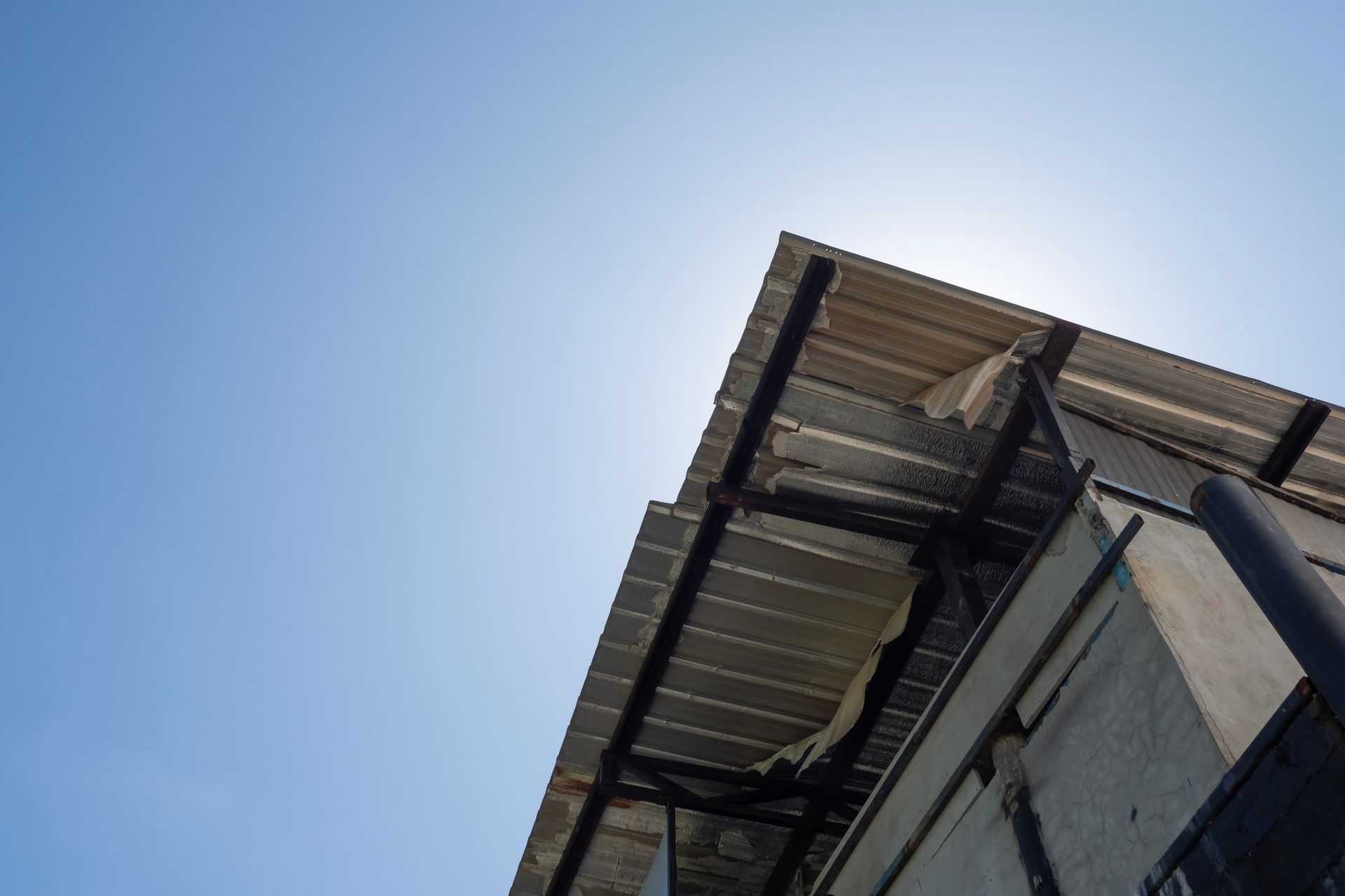 Looking up at the roof of a building with a blue sky in the background