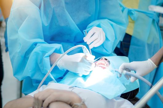 Dentista durante intervento chirurgo dentale