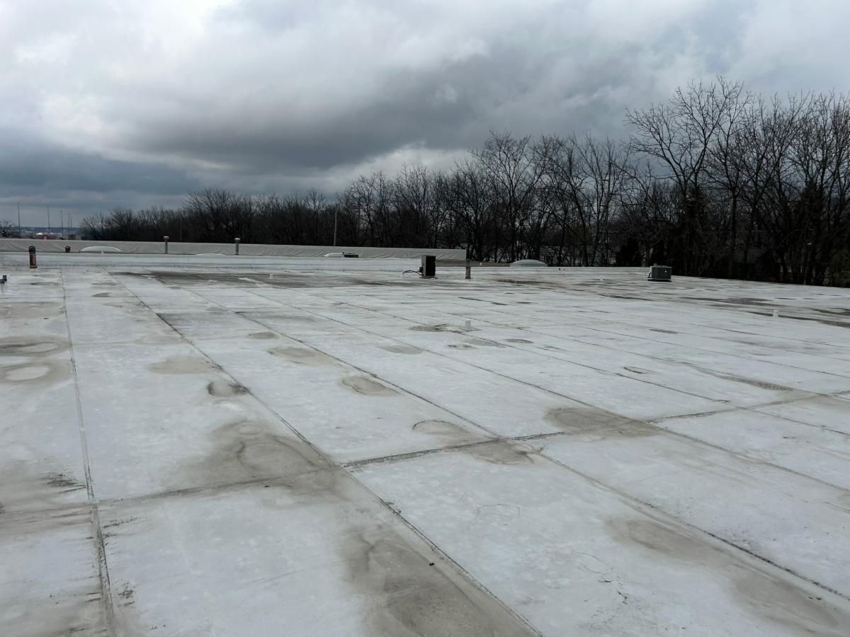 White flat roof with vents and pipes.