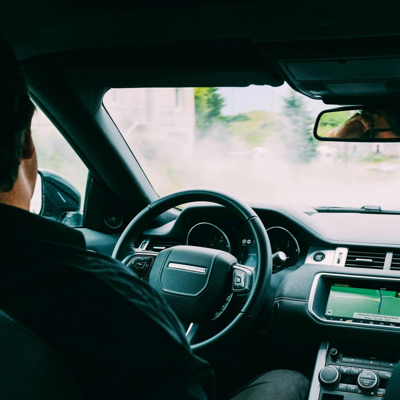 Persona conduciendo un Range Rover. 