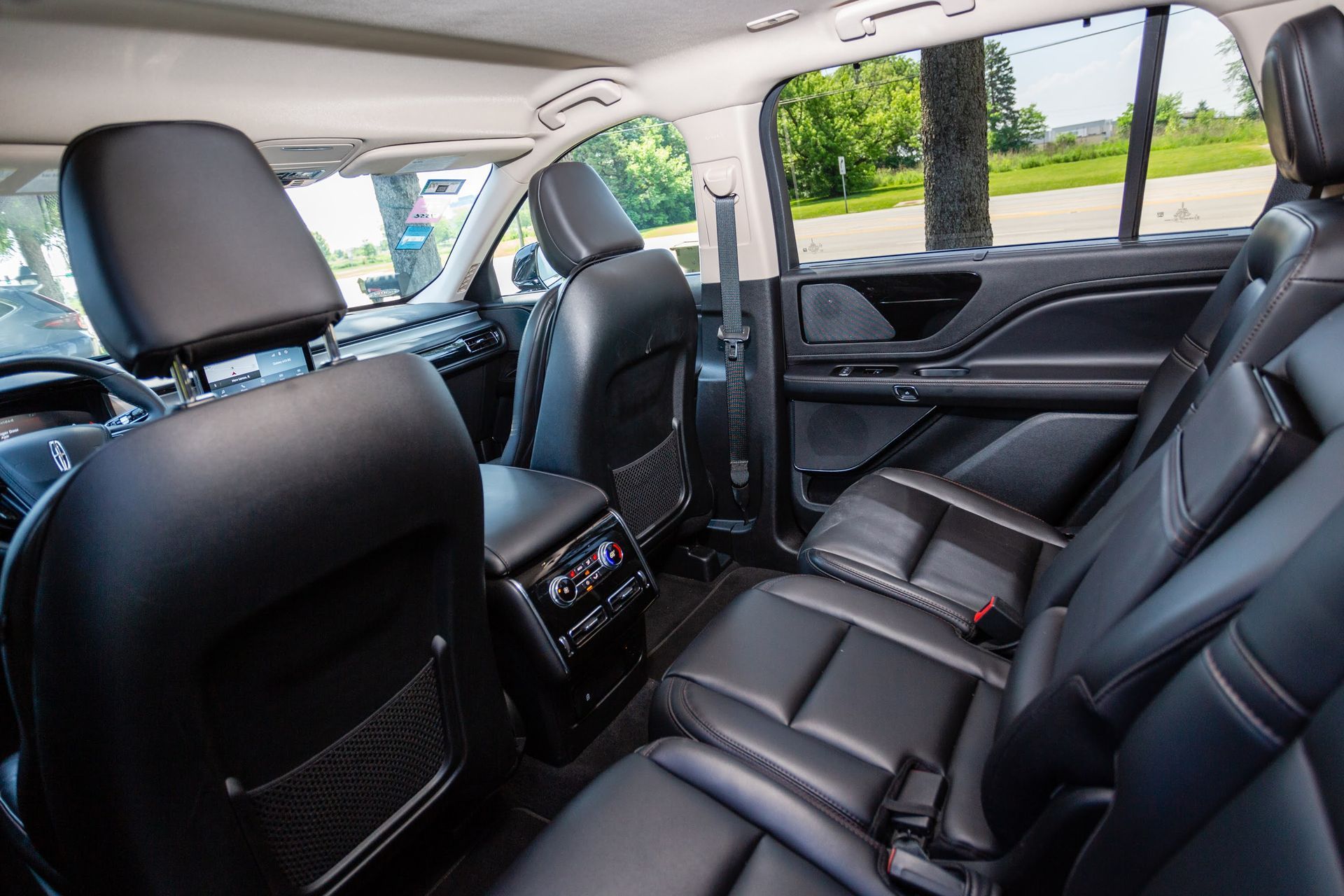 Interior of a black leather-seated SUV. Back seats are visible, along with the center console.