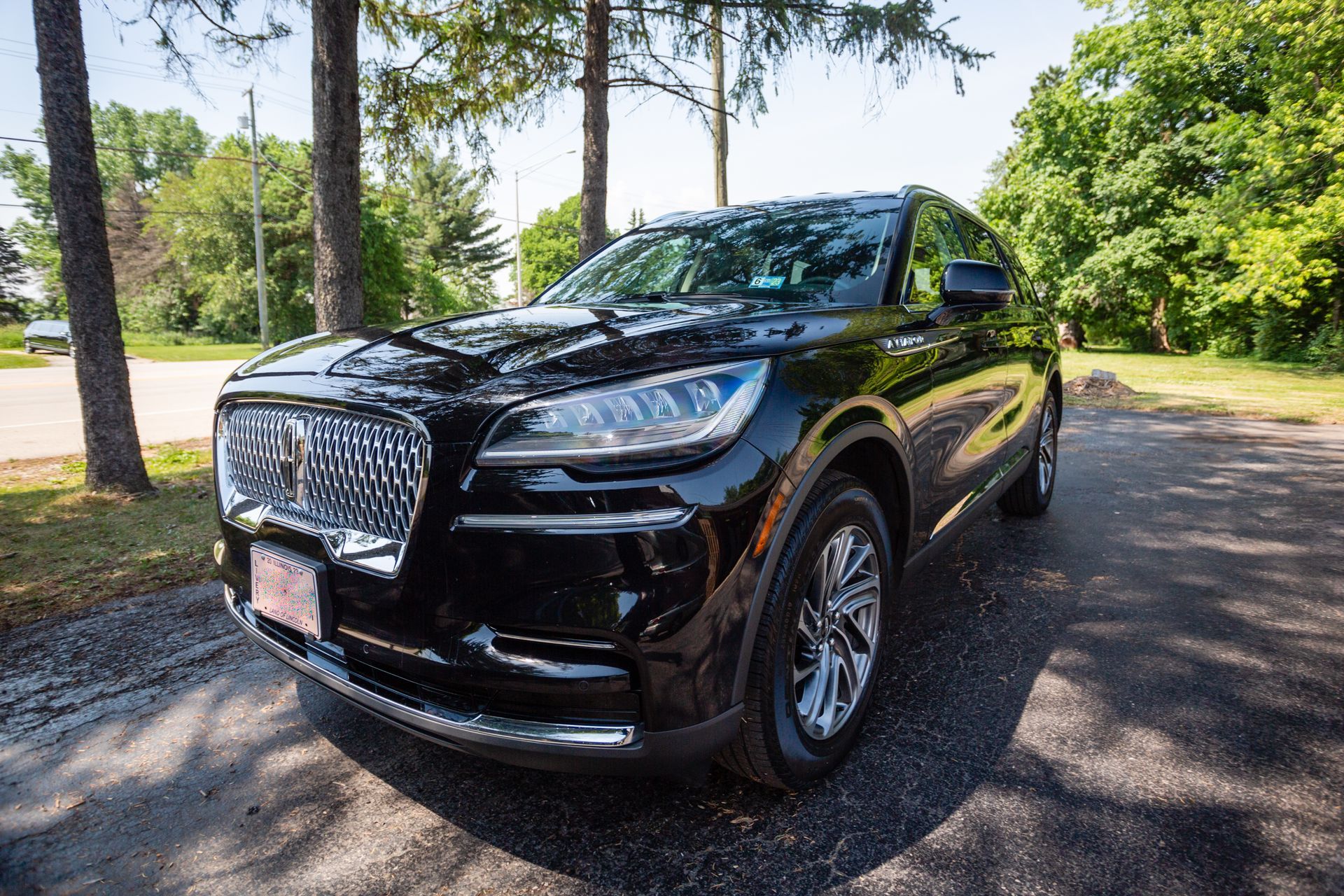 A black lincoln aviator is parked on the side of the road.