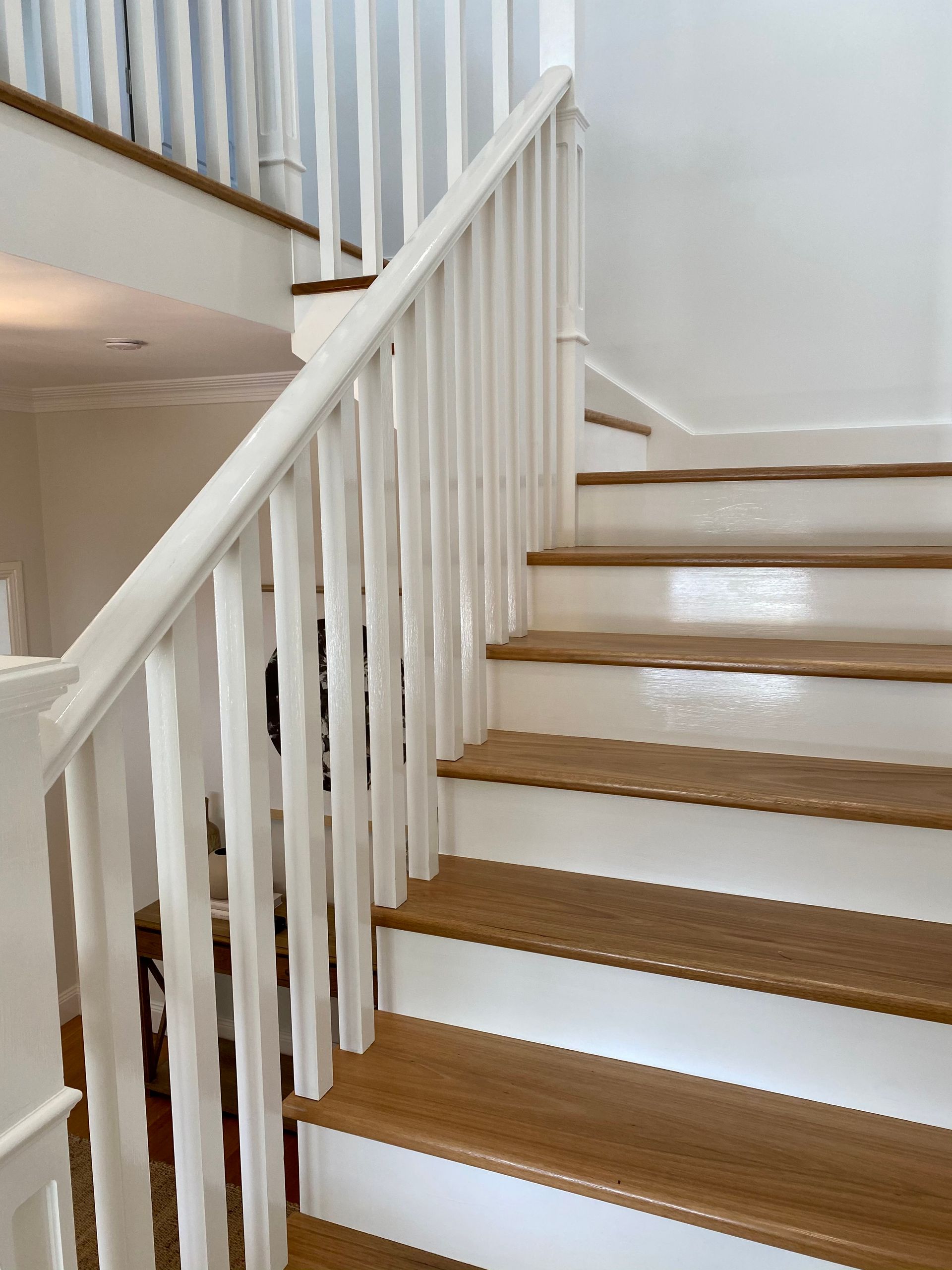 Wooden staircase with white banister and railing.