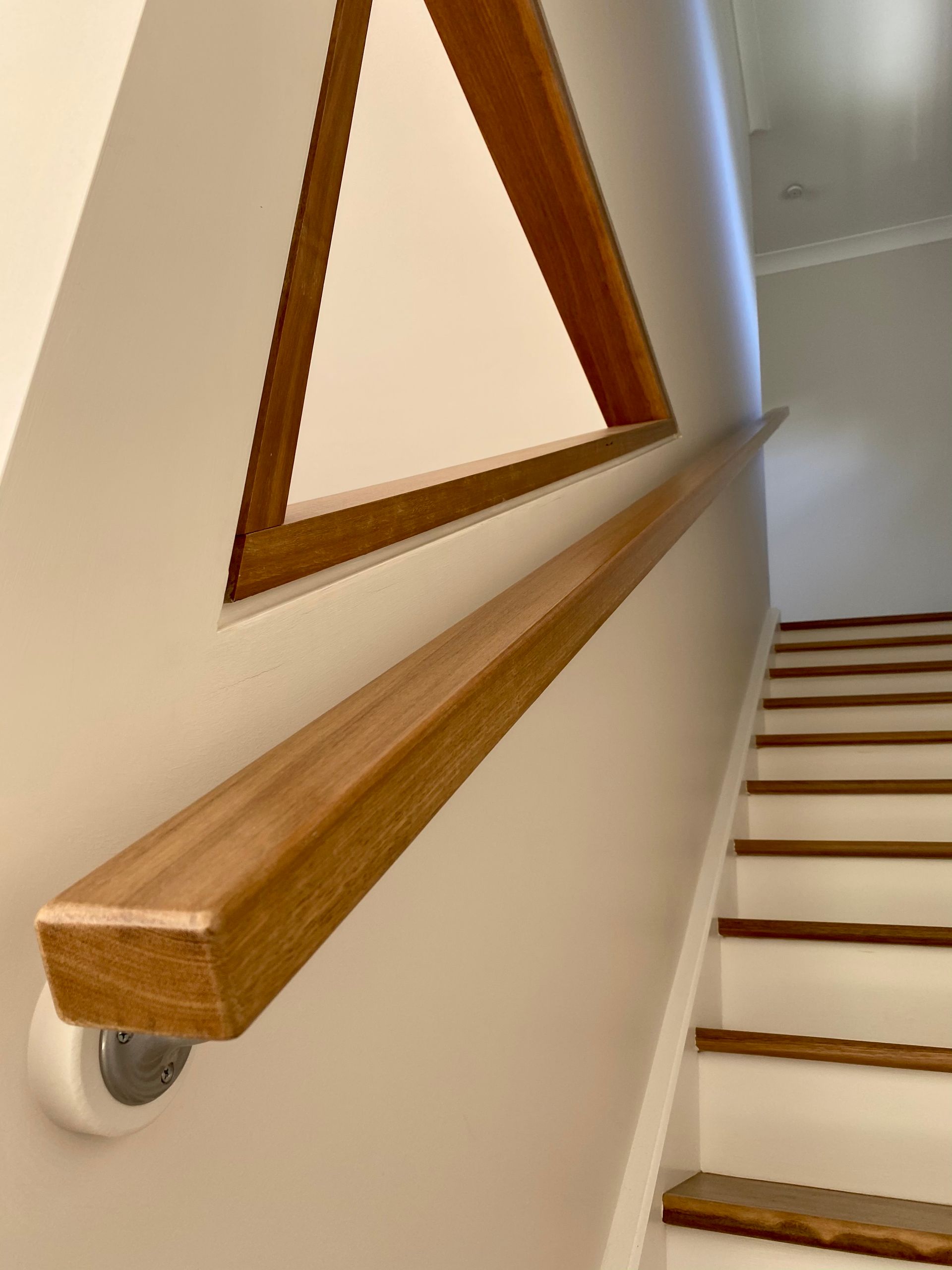 Wooden staircase with cable railing leads to a loft overlooking a pool table.