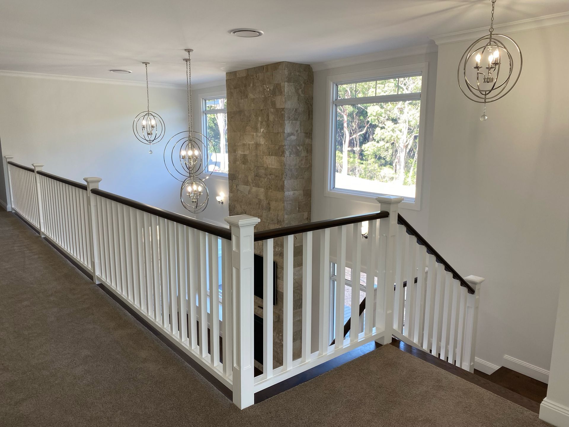 Wooden staircase with metal and wire railing, ascending against a light-colored wall.