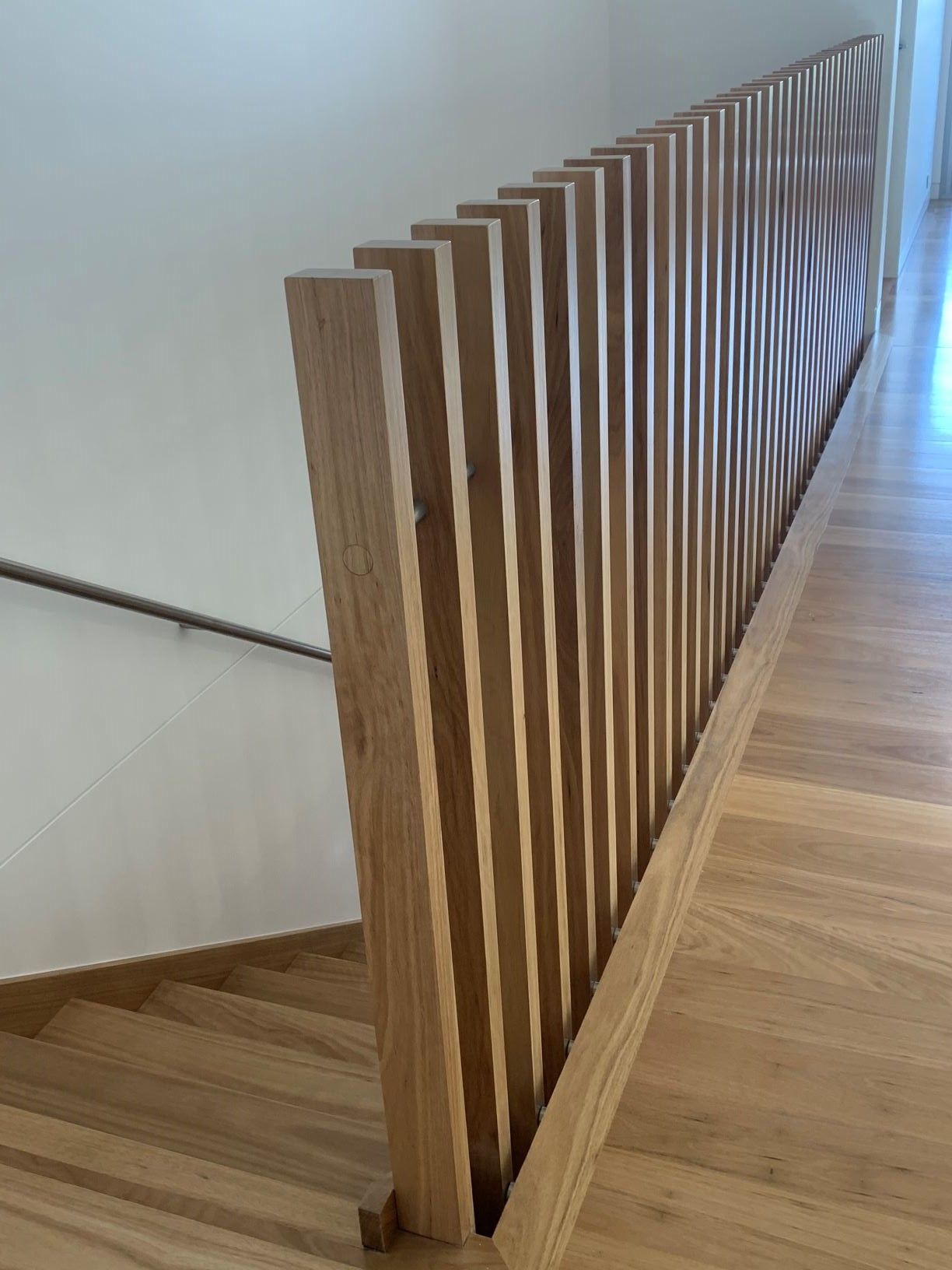 Wooden staircase with vertical wood slat railing.