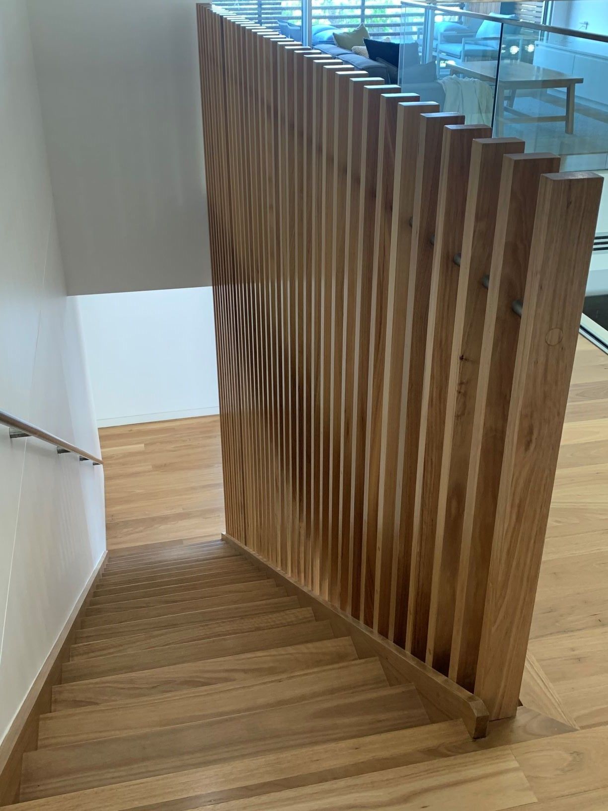 Wooden staircase with vertical slat railing.